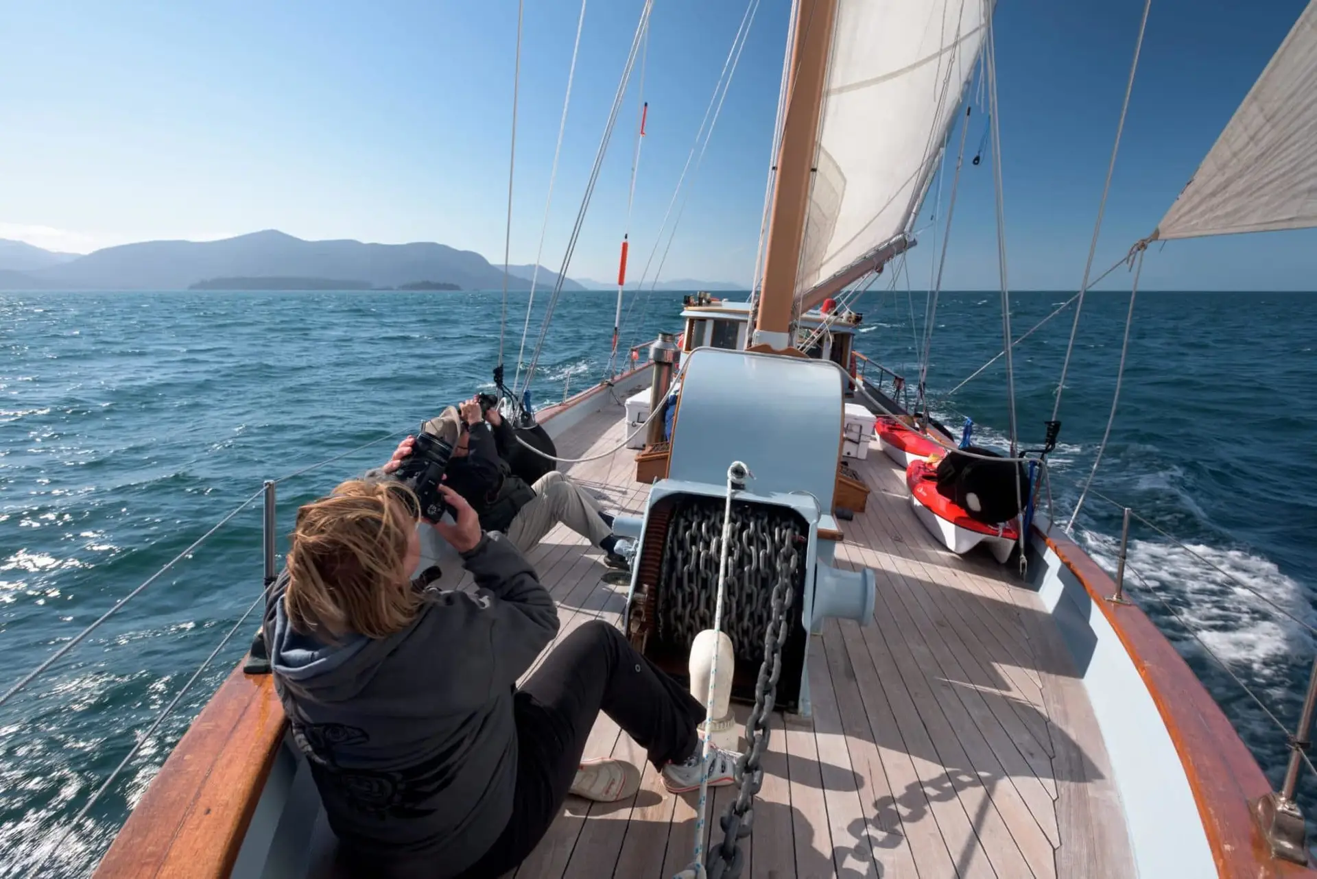 guests-aboard-schooner-passing-cloud-taking-pictures-of-sails-gwaii-haanas
