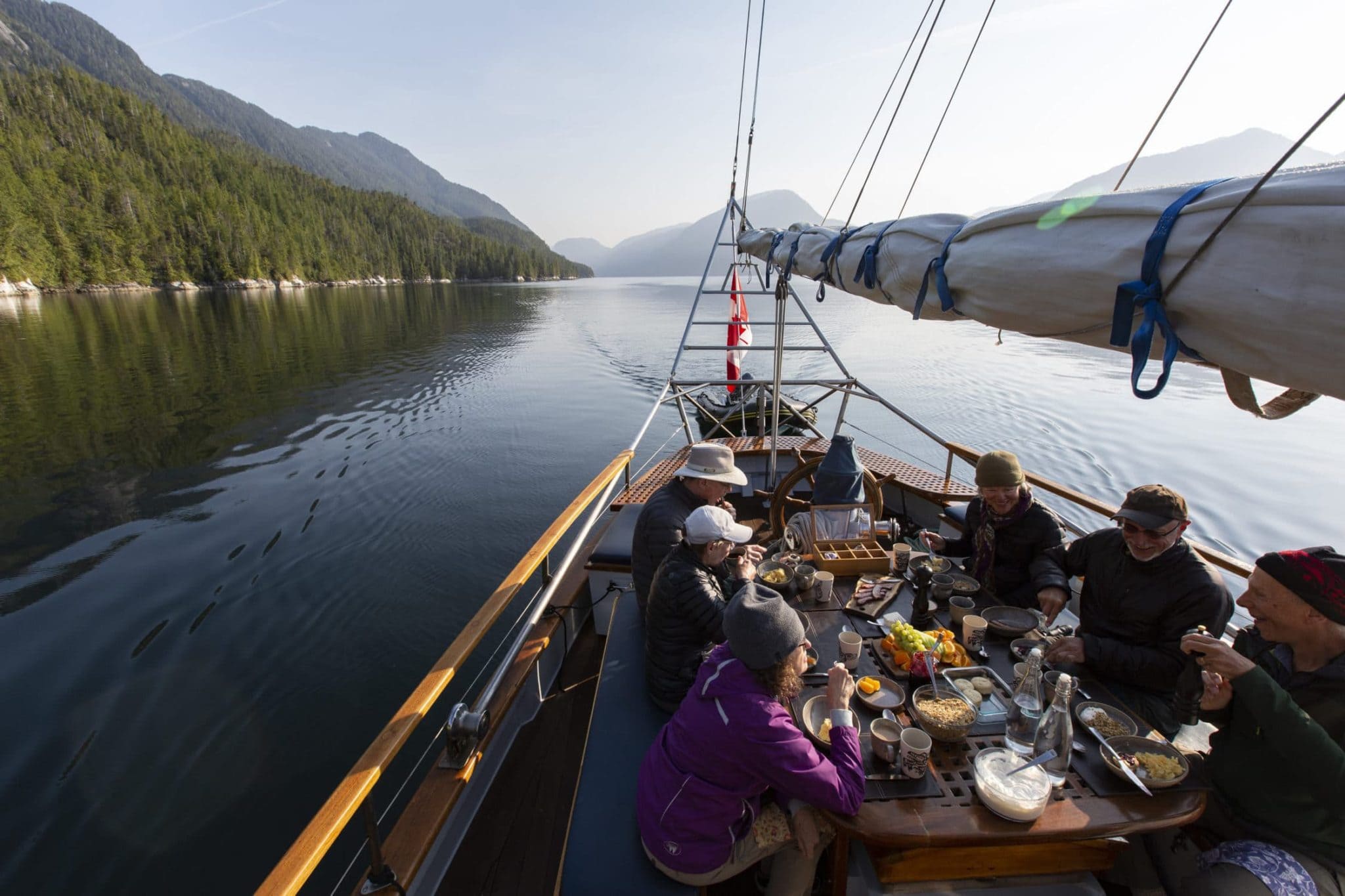 guests-enjoying-breakfast-aft-table-schooner-passing-cloud